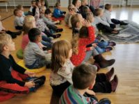 Kindergartenkinder auf Sitzkissen lauschen gespannt dem Märchenerzähler im Klubhaus Seebach.